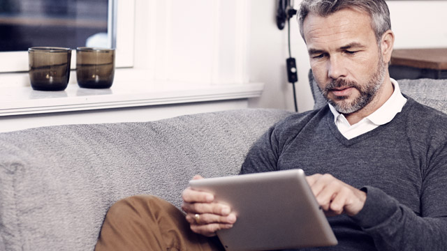 Man with tablet in sofa.